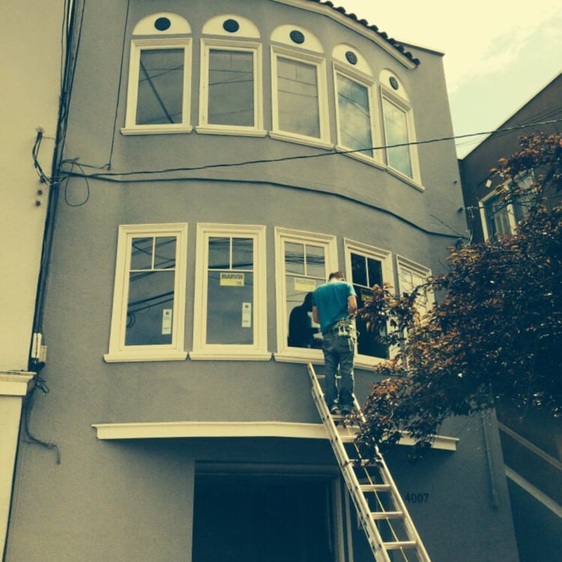 Installer replacing arched windows on San Francisco Mediterranean-style home