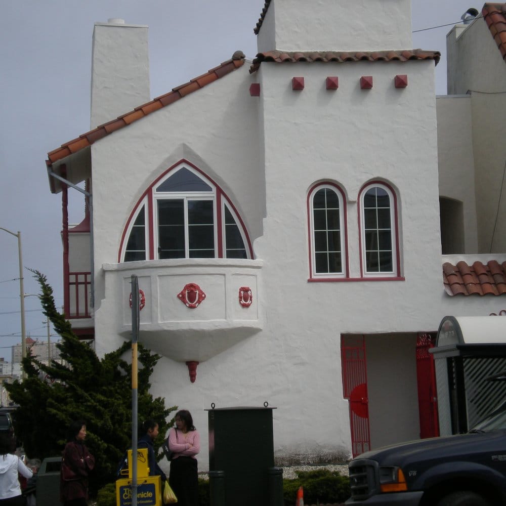Spanish Mission-style building with arched red-trim windows