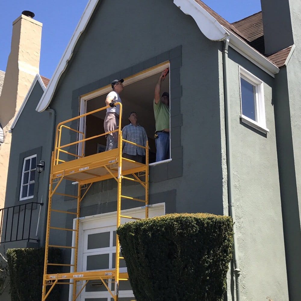 Crew installing a new window from a scaffold on a San Francisco home