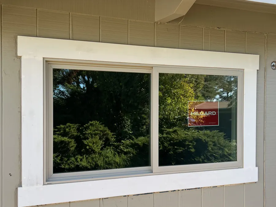New sliding window on beige vertical board siding, San Bruno, CA