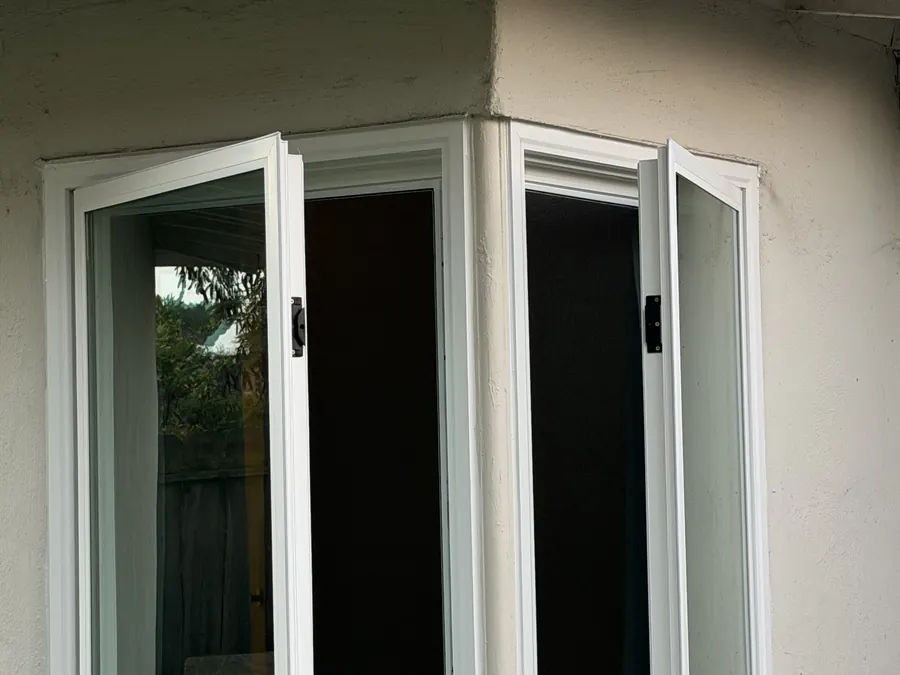 Pair of open corner casement windows on a stucco home, Millbrae, CA