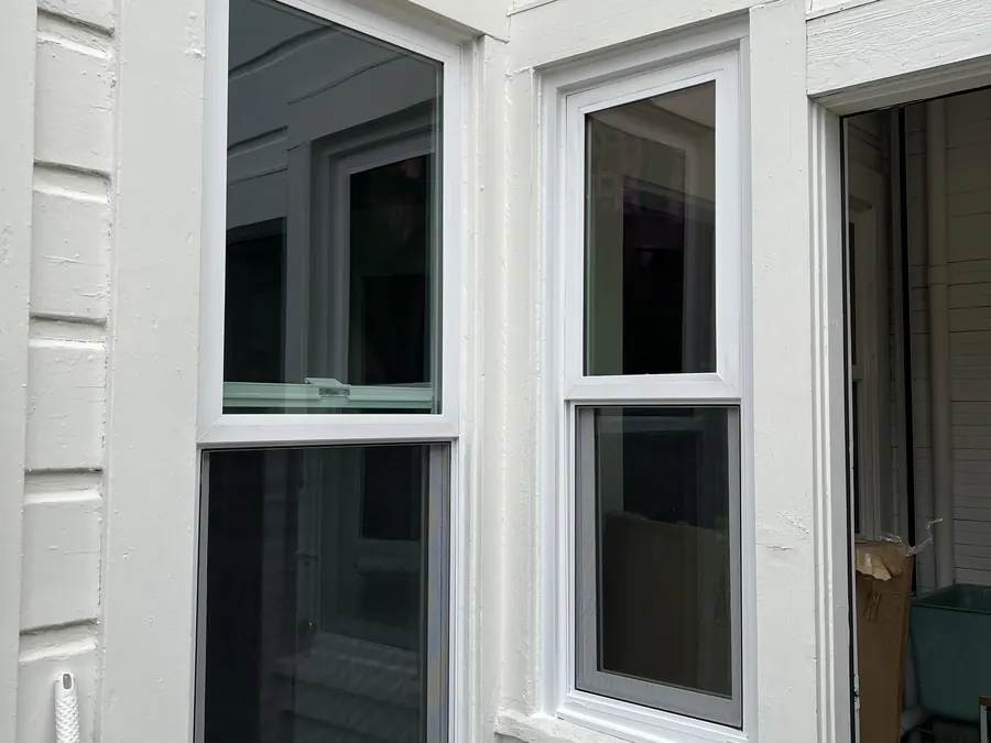 New white double-hung windows wrapping a corner of lap siding, Redwood City, CA