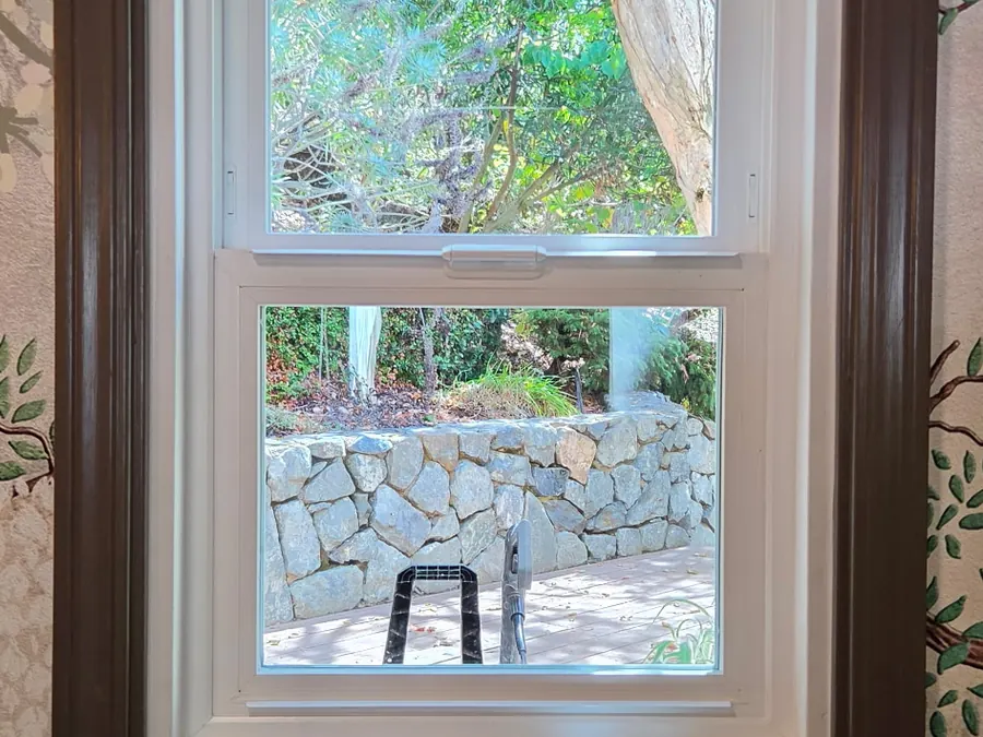 Interior view of a new double-hung window framed in dark wood trim, Palo Alto, CA