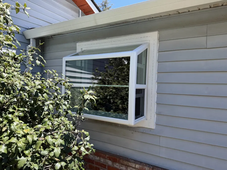 New projecting garden window on gray lap siding, San Bruno, CA