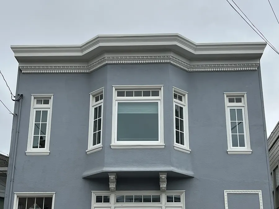 Three-story gray home with new bay and double-hung windows